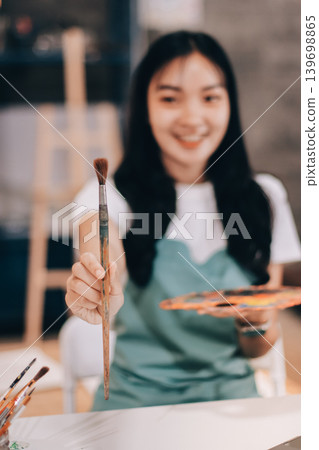 Female artist wears black hat posing near picture indoor the studio Female artist wears black hat posing near picture indoor the studio 139698865