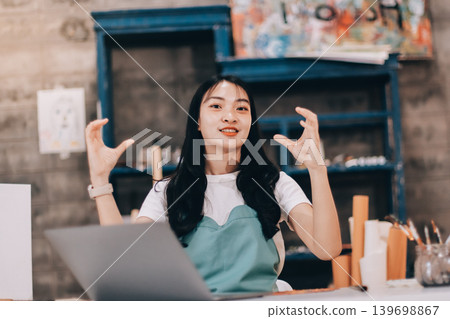 Female artist wears black hat posing near picture indoor the studio Female artist wears black hat posing near picture indoor the studio 139698867