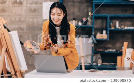 Female artist wears black hat posing near picture indoor the studio Female artist wears black hat posing near picture indoor the studio 139698870