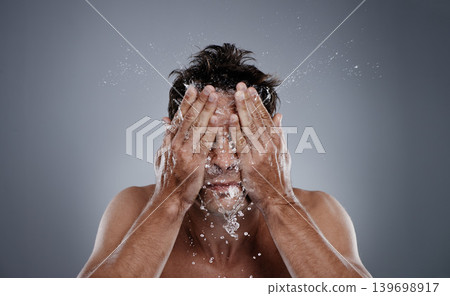 Water drops, splash and man clean face for bathroom routine, dermatology cleanse or beauty treatment. Studio, refresh and model facial washing, hygiene and grooming for clear skin on grey background Water drops, splash and man clean face for bathroom routine, dermatology cleanse or beauty treatment. Studio, refresh and model facial washing, hygiene and grooming for clear skin on grey background 139698917