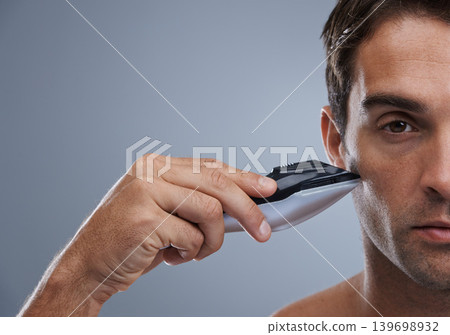 Man, electric razor and closeup studio portrait for grooming, skincare or wellness by grey background. Person, model and shaving beard with hygiene, facial hair removal or product for cosmetic change Man, electric razor and closeup studio portrait for grooming, skincare or wellness by grey background. Person, model and shaving beard with hygiene, facial hair removal or product for cosmetic change 139698932
