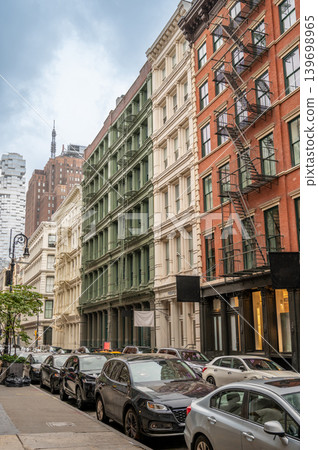 New york, usa august 18,2024. Soho cast iron facades and fire escapes line a multistory manhattan street with parked cars, historic urban architecture by day New york, usa august 18,2024. Soho cast iron facades and fire escapes line a multistory manhattan street with parked cars, historic urban architecture by day 139698965