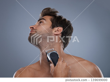 Man, electric shaver and beard in studio for grooming, skincare or wellness for neck by grey background. Person, model and self care for hygiene, facial hair removal or clippers for cosmetic change 139699000
