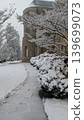 Historic stone university campus building and walkway during winter snowfall. 139699073