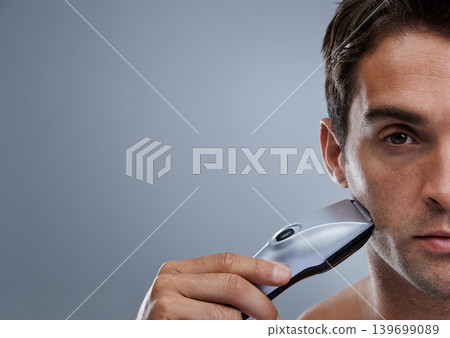 Man, electric razor and studio with space for grooming, skincare and wellness in mockup by grey background. Person, model and beard with hygiene, facial hair removal and promotion for cosmetic change Man, electric razor and studio with space for grooming, skincare and wellness in mockup by grey background. Person, model and beard with hygiene, facial hair removal and promotion for cosmetic change 139699089