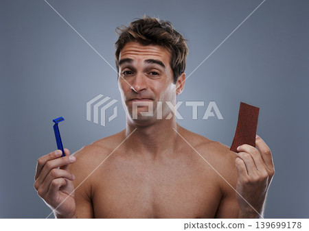 Man, hair removal and choice with doubt, razor and beauty with decision and studio background with options and products. Face, wellness or model shaving for skincare, routine treatment and sand paper Man, hair removal and choice with doubt, razor and beauty with decision and studio background with options and products. Face, wellness or model shaving for skincare, routine treatment and sand paper 139699178