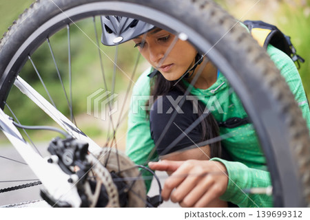Woman, mountain bike and repair wheel outdoor with thinking, preparation and vision for race in nature. Girl, person and bicycle with maintenance, check and inspection with helmet for safety on trail Woman, mountain bike and repair wheel outdoor with thinking, preparation and vision for race in nature. Girl, person and bicycle with maintenance, check and inspection with helmet for safety on trail 139699312