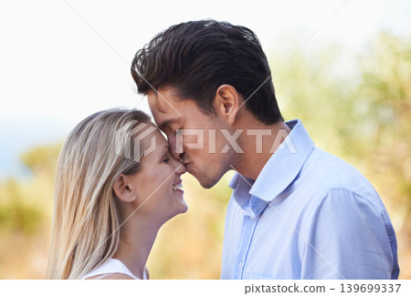 Happy couple, kiss and nature for romance, support or affection in outdoor bonding or date. Young man kissing woman on nose with smile for embrace, comfort or love in forest or woods outside together Happy couple, kiss and nature for romance, support or affection in outdoor bonding or date. Young man kissing woman on nose with smile for embrace, comfort or love in forest or woods outside together 139699337