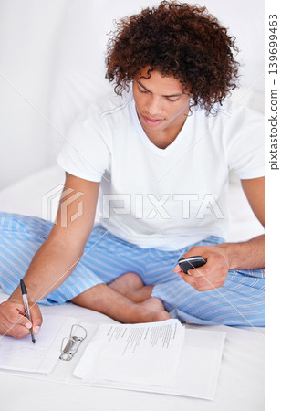 Working, man in bedroom and cellphone for work from home, writing and sitting in pyjamas for freelance. Technology, entrepreneur and remote worker for online job, documents and business projects Working, man in bedroom and cellphone for work from home, writing and sitting in pyjamas for freelance. Technology, entrepreneur and remote worker for online job, documents and business projects 139699463