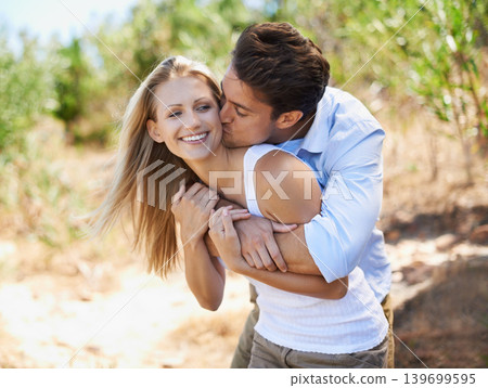 Mwah. Couple, face and happy with kiss in nature or relationship for holiday, vacation or travel. Romance, man and woman with smile outdoor in forest with embrace for bonding, love or relax in woods. Mwah. Couple, face and happy with kiss in nature or relationship for holiday, vacation or travel. Romance, man and woman with smile outdoor in forest with embrace for bonding, love or relax in woods. 139699595