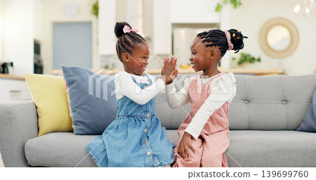 Kids, high five and couch in a home with young, smile and happy from sibling bonding together. House, lounge sofa and daughter friends with talk and girl friendship with fun and youth in living room Kids, high five and couch in a home with young, smile and happy from sibling bonding together. House, lounge sofa and daughter friends with talk and girl friendship with fun and youth in living room 139699760