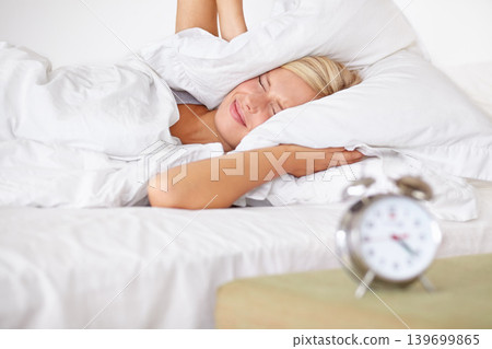 Tired, woman and frustrated with alarm in bed with stress and fatigue in morning at home. Wake up, time and girl to start day, routine and clock in bedroom or cover sound with pillow in apartment Tired, woman and frustrated with alarm in bed with stress and fatigue in morning at home. Wake up, time and girl to start day, routine and clock in bedroom or cover sound with pillow in apartment 139699865