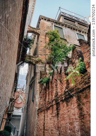Narrow Venetian alley at daylight with authentic historic silent atmosphere Narrow Venetian alley at daylight with authentic historic silent atmosphere 139700234
