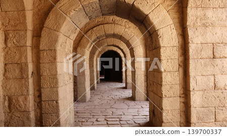 Ancient stone corridor with repeating arches illuminated by warm natural light, Ancient stone corridor with repeating arches illuminated by warm natural light, 139700337