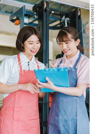 女員工在倉庫裡愉快地工作 女員工在倉庫裡愉快地工作 139700433