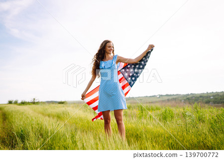 Young woman with american USA flag on blooming meadow. Independence Day, 4th July. 139700772