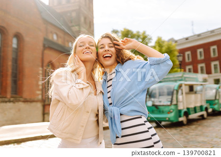 Female tourists in bright dress enjoys sights of city on sunny day. Concept of lifestyle, fashion. Female tourists in bright dress enjoys sights of city on sunny day. Concept of lifestyle, fashion. 139700821