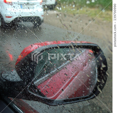 A car tries to overtake another car on a highway that is wet from heavy rain A car tries to overtake another car on a highway that is wet from heavy rain 139700990