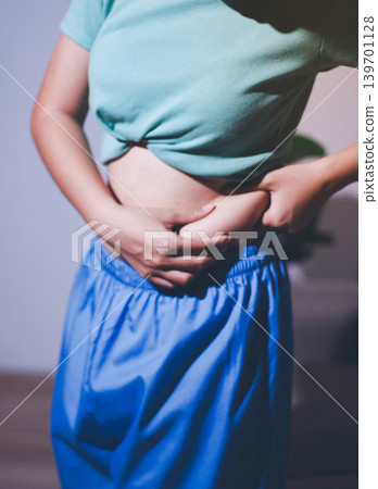 Overweight woman body with hands touching belly fat 139701128