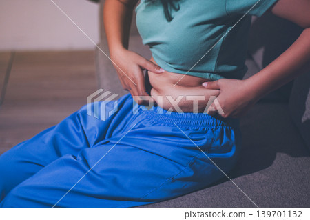 Overweight woman body with hands touching belly fat 139701132