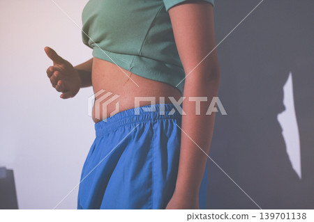 Overweight woman body with hands touching belly fat Overweight woman body with hands touching belly fat 139701138