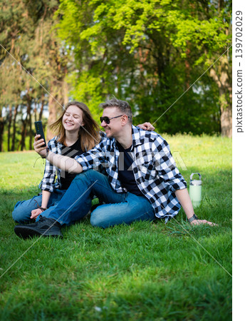 Father And Daughter Happily Taking A Selfie While Sitting On The Grass Father And Daughter Happily Taking A Selfie While Sitting On The Grass 139702029