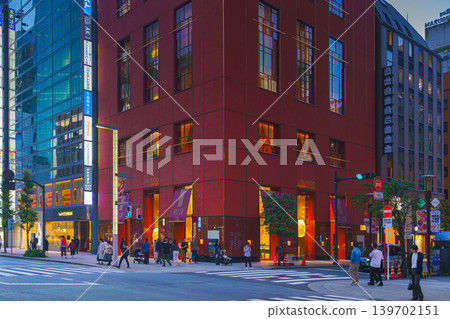 Tokyo, Japan - Oct 14 2024, panoramic view of main street of Ginza district, tall glass facades of skyscrapers along which people walk, cars drive along road, in evening with illumination, Tokyo Japan Tokyo, Japan - Oct 14 2024, panoramic view of main street of Ginza district, tall glass facades of skyscrapers along which people walk, cars drive along road, in evening with illumination, Tokyo Japan 139702151