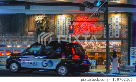 Tokyo, Japan - Oct 14 2024, panoramic view of entrance to a restaurant located under a bridge, with people standing near passage, with black cab taxi driving, n Ginza district, at night, Tokyo, Japan Tokyo, Japan - Oct 14 2024, panoramic view of entrance to a restaurant located under a bridge, with people standing near passage, with black cab taxi driving, n Ginza district, at night, Tokyo, Japan 139702165