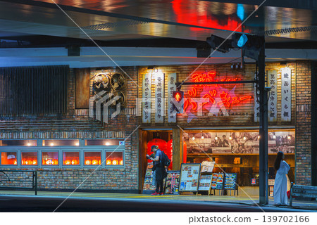 Tokyo, Japan - Oct 14 2024, panoramic view of the entrance to a restaurant located under a bridge, with people standing near the passage, in the Ginza district, at night, Tokyo, Japan 139702166