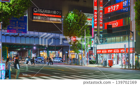 Tokyo, Japan - Oct 14 2024, panoramic view of people crossing road at pedestrian crossing in Ginza district, with many illuminated signage on facades of skyscrapers in background and cars Tokyo, Japan - Oct 14 2024, panoramic view of people crossing road at pedestrian crossing in Ginza district, with many illuminated signage on facades of skyscrapers in background and cars 139702169