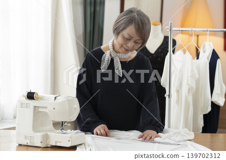 資深女設計師在她們的工作室裡製作服裝。 139702312