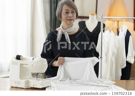 資深女設計師在她們的工作室裡製作服裝。 資深女設計師在她們的工作室裡製作服裝。 139702318