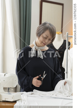 資深女設計師在她們的工作室裡製作服裝。 139702335