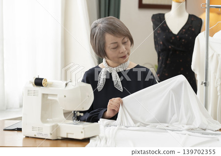 Senior female designers create clothes in their atelier. Senior female designers create clothes in their atelier. 139702355