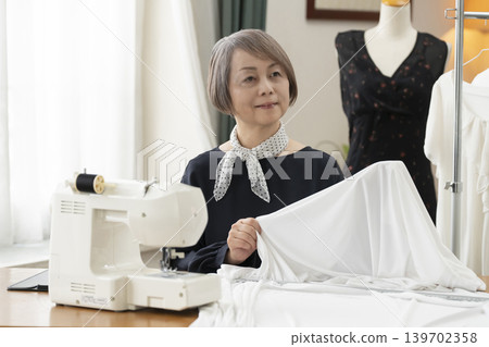 資深女設計師在她們的工作室裡製作服裝。 139702358