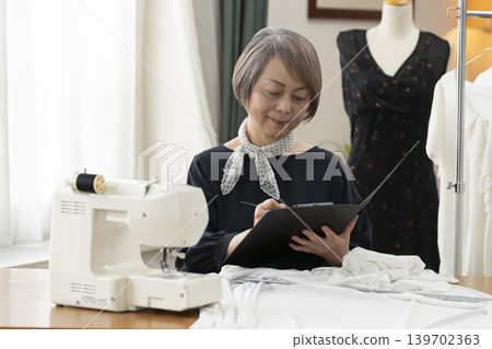 資深女設計師在她們的工作室裡製作服裝。 139702363