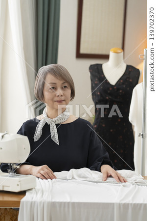 資深女設計師在她們的工作室裡製作服裝。 139702370
