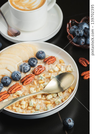 Oatmeal. Bowl of oatmeal porridge with blackberry, bananas and chia seeds on gray concrete old table background. Top view in flat lay style. Natural ingredients. Hot healthy breakfast and diet food Oatmeal. Bowl of oatmeal porridge with blackberry, bananas and chia seeds on gray concrete old table background. Top view in flat lay style. Natural ingredients. Hot healthy breakfast and diet food 139702395