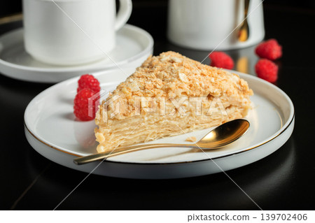 Sliced Napoleon cake on a white wooden table. Classic dessert Sliced Napoleon cake on a white wooden table. Classic dessert 139702406