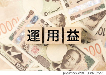 一塊標有「投資收益」的鈔票和大量10000日元紙幣。 139702555