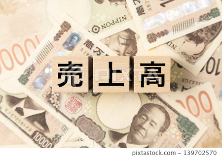 一塊標示「銷售收入」的鈔票和大量10000日元紙幣。 一塊標示「銷售收入」的鈔票和大量10000日元紙幣。 139702570