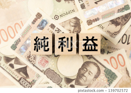 一塊寫著「淨利」的鈔票和許多10,000日圓面額的鈔票。 一塊寫著「淨利」的鈔票和許多10,000日圓面額的鈔票。 139702572