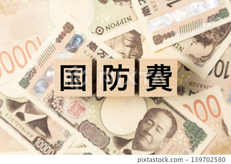 A block labeled "Defense Spending" and a large number of 10,000 yen bills. A block labeled "Defense Spending" and a large number of 10,000 yen bills. 139702580
