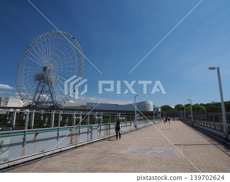 A refreshing breeze blows through the Expo Park pathway in early summer. The sky stretches endlessly, and modern leisure facilities abound. A refreshing breeze blows through the Expo Park pathway in early summer. The sky stretches endlessly, and modern leisure facilities abound. 139702624