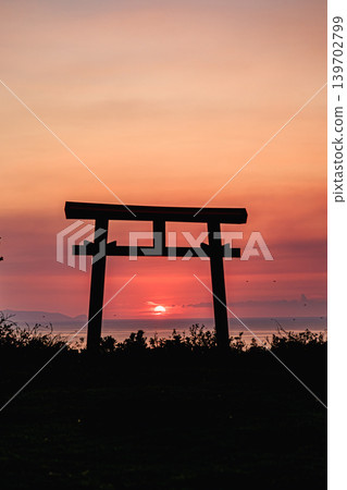 The light of the setting sun stretching across the sea and the torii gate of Yahazudake Shrine on Yakushima Island. 139702799