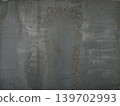 This image shows an outdoor industrial tank being buffed to roughen the surface before painting during construction. 139702993