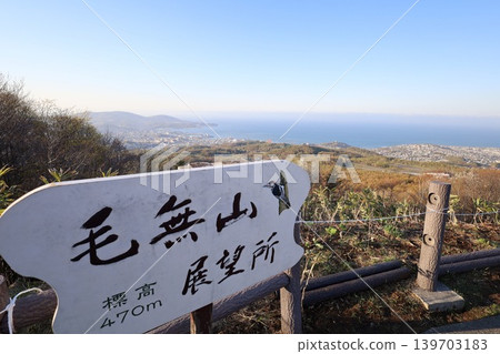In early May, in Hokkaido, a view of Otaru, Hokkaido, from the observation point on Mount Kenashi, overlooking the harbor and Ishikari Bay, against a blue sky and evening twilight. In early May, in Hokkaido, a view of Otaru, Hokkaido, from the observation point on Mount Kenashi, overlooking the harbor and Ishikari Bay, against a blue sky and evening twilight. 139703183