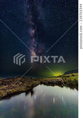 The Milky Way stretching across the night sky of Yakushima and the starry scenery reflected on the water's surface. The Milky Way stretching across the night sky of Yakushima and the starry scenery reflected on the water's surface. 139703344