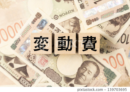 一塊標示「可變費用」的鈔票和大量10,000日圓面額的鈔票。 139703695