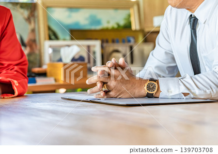 The close up of businessman hand using a blue pen to sign the signature on the contract agreement paper document in the conference with the partner. The close up of businessman hand using a blue pen to sign the signature on the contract agreement paper document in the conference with the partner. 139703708